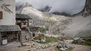 A man and two women are hiking in the Sexten Dolomites