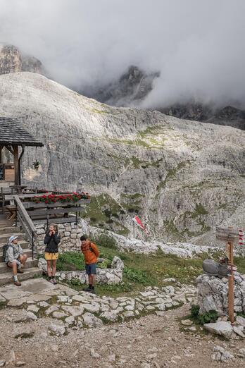 Un uomo e due donne camminano nelle Dolomiti di Sesto