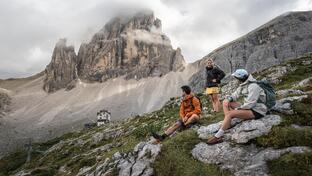 A man and two women are hiking in the Sexten Dolomites