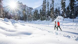 Two women are hiking in the snow