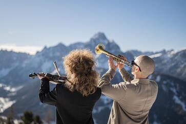 Un uomo suona la tromba mentre una donna accanto a lui suona il violino