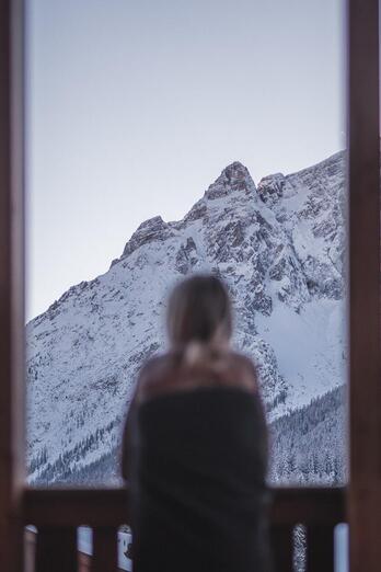 A woman looks at the snow-covered Dolomites