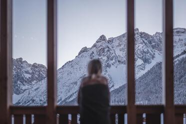 A woman looks at the snow-covered Dolomites