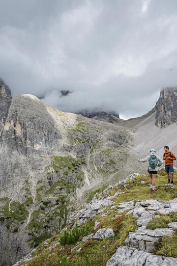 Two women and a man are looking at the Dolomites