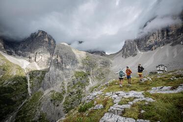 Two women and a man are looking at the Dolomites