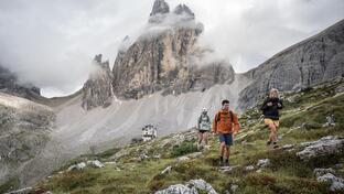 A man and two women are hiking in the Sexten Dolomites