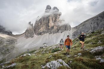 Un uomo e due donne camminano nelle Dolomiti di Sesto