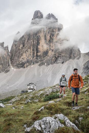 A man and two women are hiking in the Sexten Dolomites