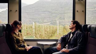 A man and a woman are sitting on the train