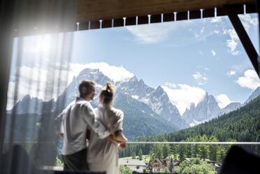 A man and a woman look at a mountain landscape