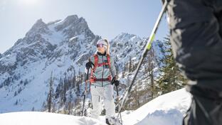 A man and a woman are ski touring