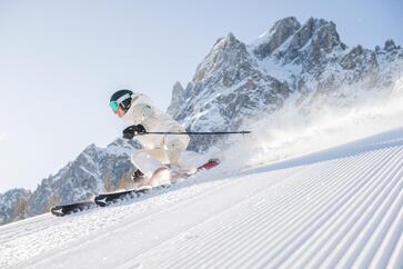A skier is skiing downhill on a snow-covered slope